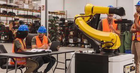 engineers programming robotic arm in modern factor