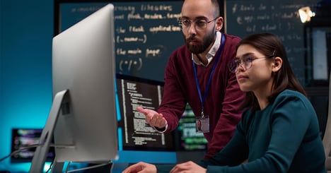 two leaders using a computer and discussing